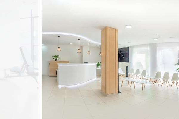 A clinic reception and waiting area with a timber counter and plants