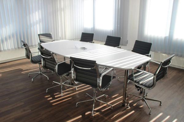 A boardroom with a long table and leather chairs, cleaned and ready for a meeting