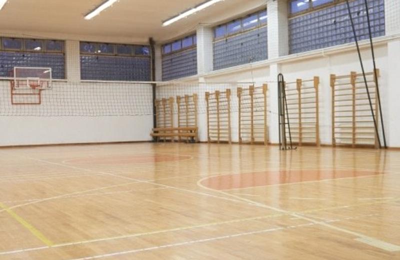 A school gymnasium with a polished wooden floor and wall bars